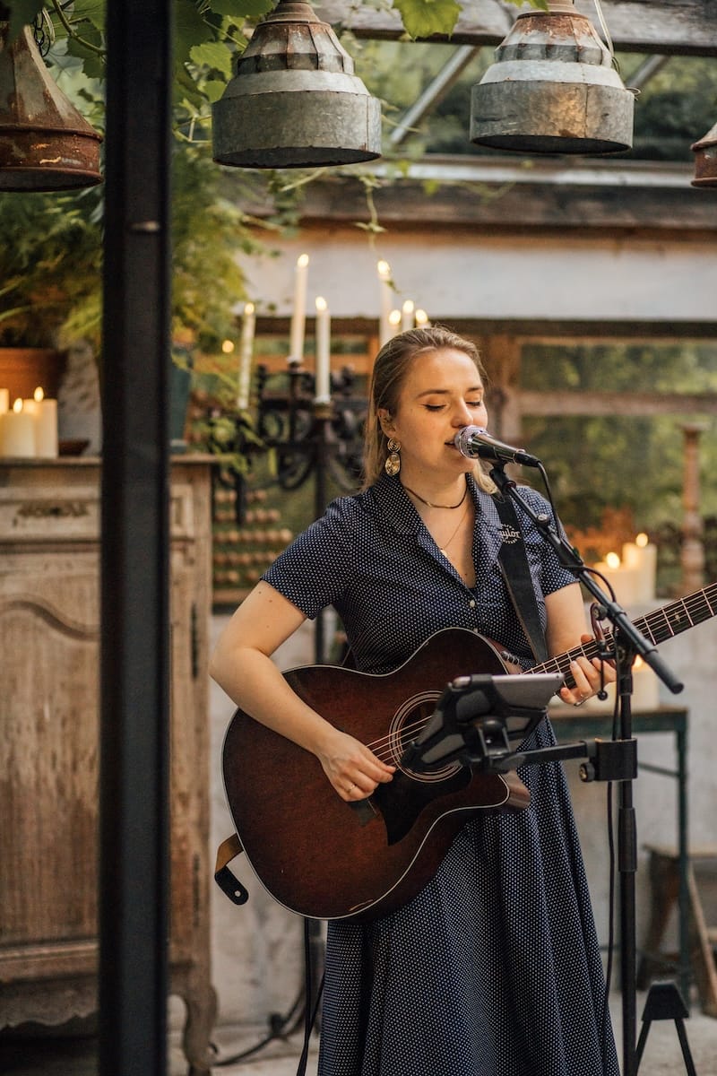 Bruiloft zangeres met gitaar tijdens de borrel op een bruiloft